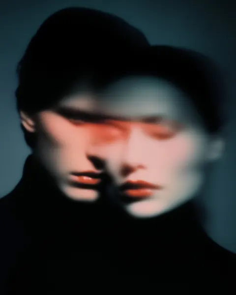 Portrait of a man and a woman merging faces, long exposure blur lines flowing across their faces