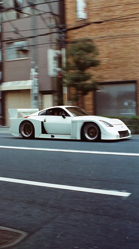 Panning shot of a Nissan 350Z Turbo from Group 5 race cars with a massive widebody and aero