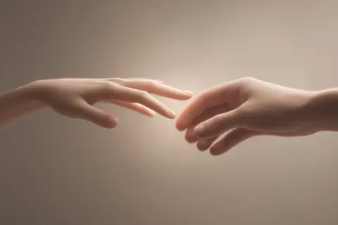Artistic close-up of a woman's hand gently touching a man's side, soft warm light