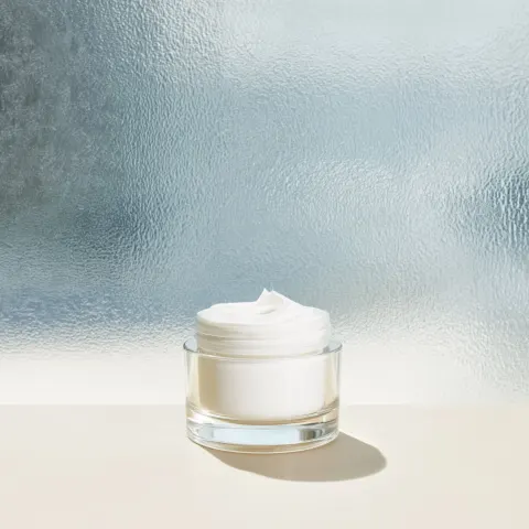 Type: Hero Shot what we see: The cream standing on a pale clean surface inside a bright modern lab w