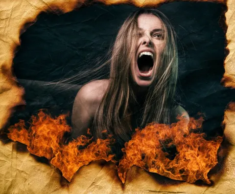 A woman is screaming into the camera. The image texture OVERALL is OLD paper burning. paper texture