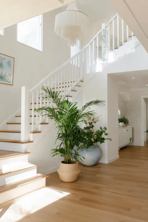 A white staircase with wooden flooring, white walls