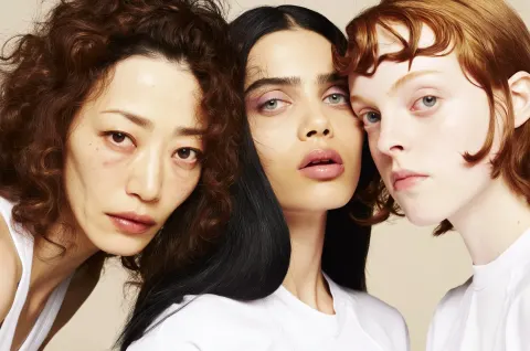 A photo of three diverse women with different hair and skin tones, each wearing white