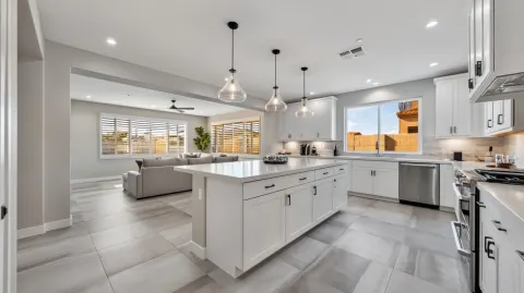 1. KITCHEN (facing east toward living room): Professional real estate photograph of a new constructi