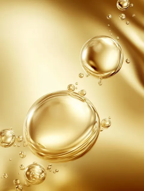 Three large transparent spherical molecules float freely in a light golden abstract environment. The