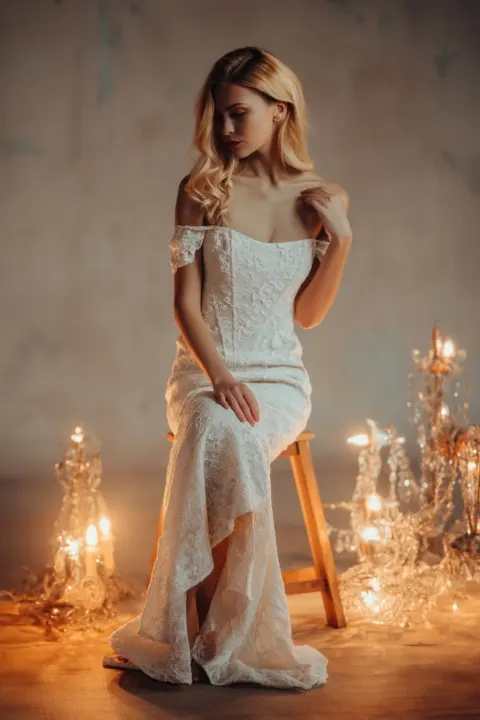 Ultra-realistic fashion editorial, elegant blonde European woman seated on a simple wooden stool
