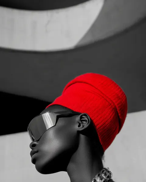 Artistic profile closeup, black-skinned model in bold mirrored wrap-around sunglasses