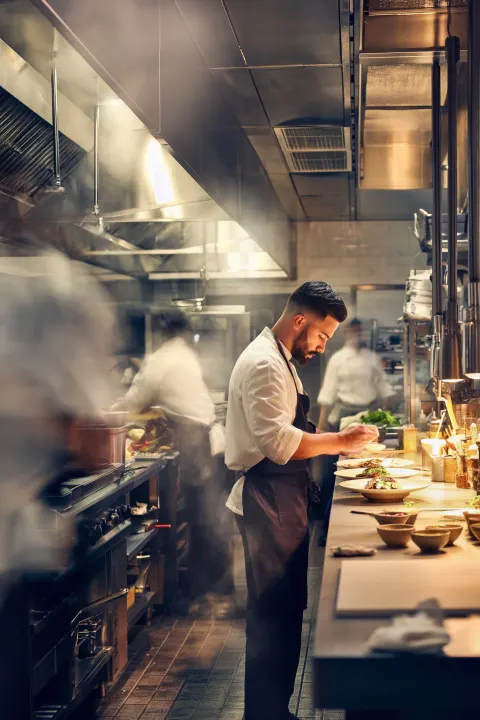 Professional restaurant kitchen during service, clean and organized workspace